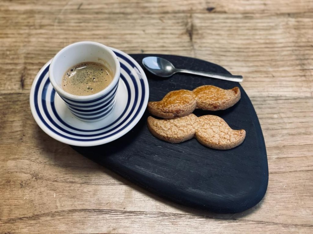 Un café avec un biscuit en forme de moustache